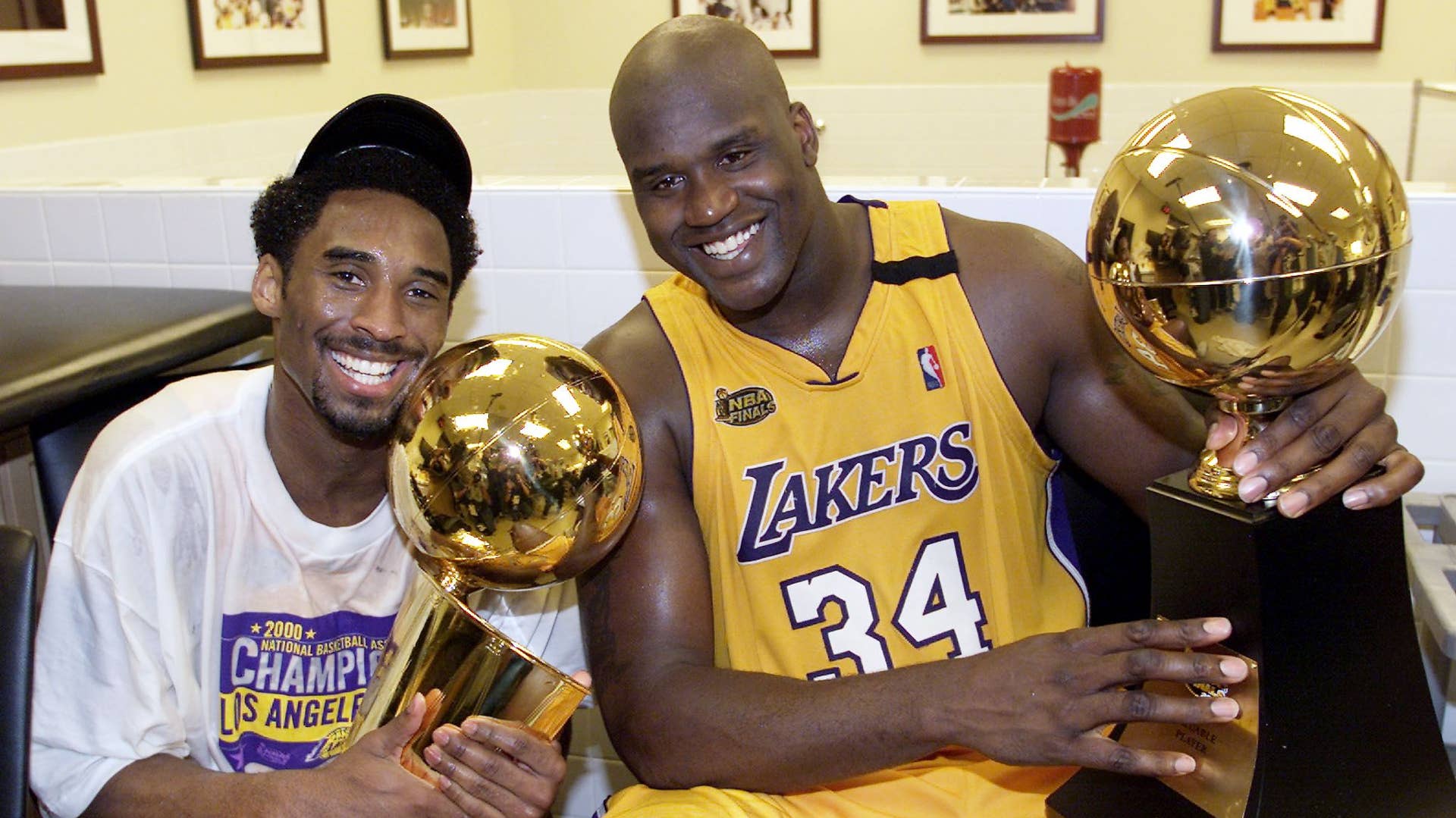 Kobe Bryant holds Larry O'Brien trophy as Shaq clutches the MVP trophy.