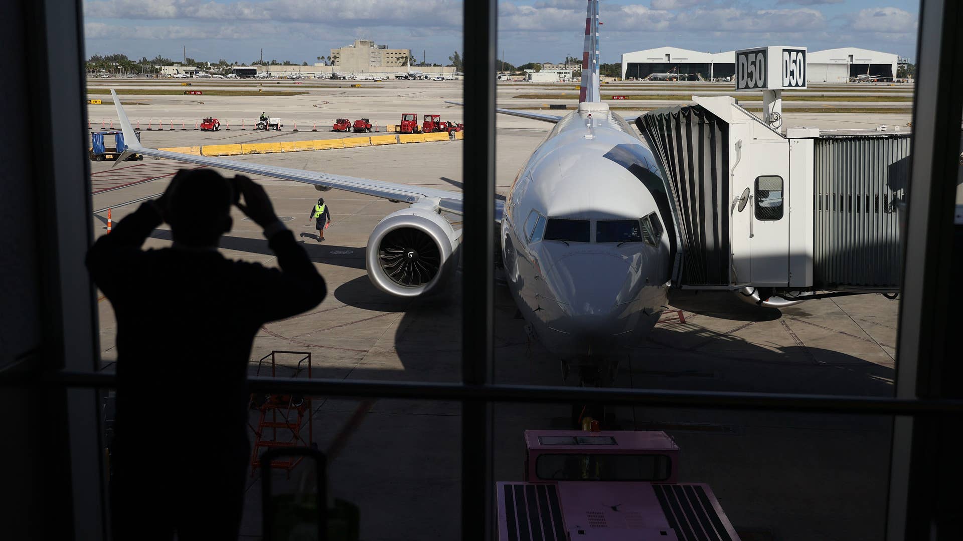 American Airlines flight 718, a Boeing 737 Max, is seen parked at its gate at Miami International Airport as passengers board for the flight to New York.