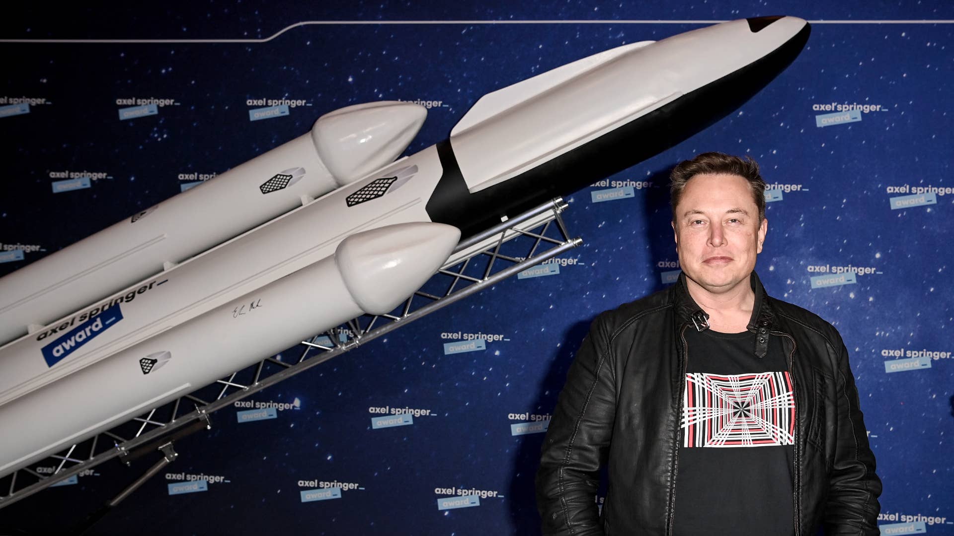 Elon Musk is seen posing in front of a rocket