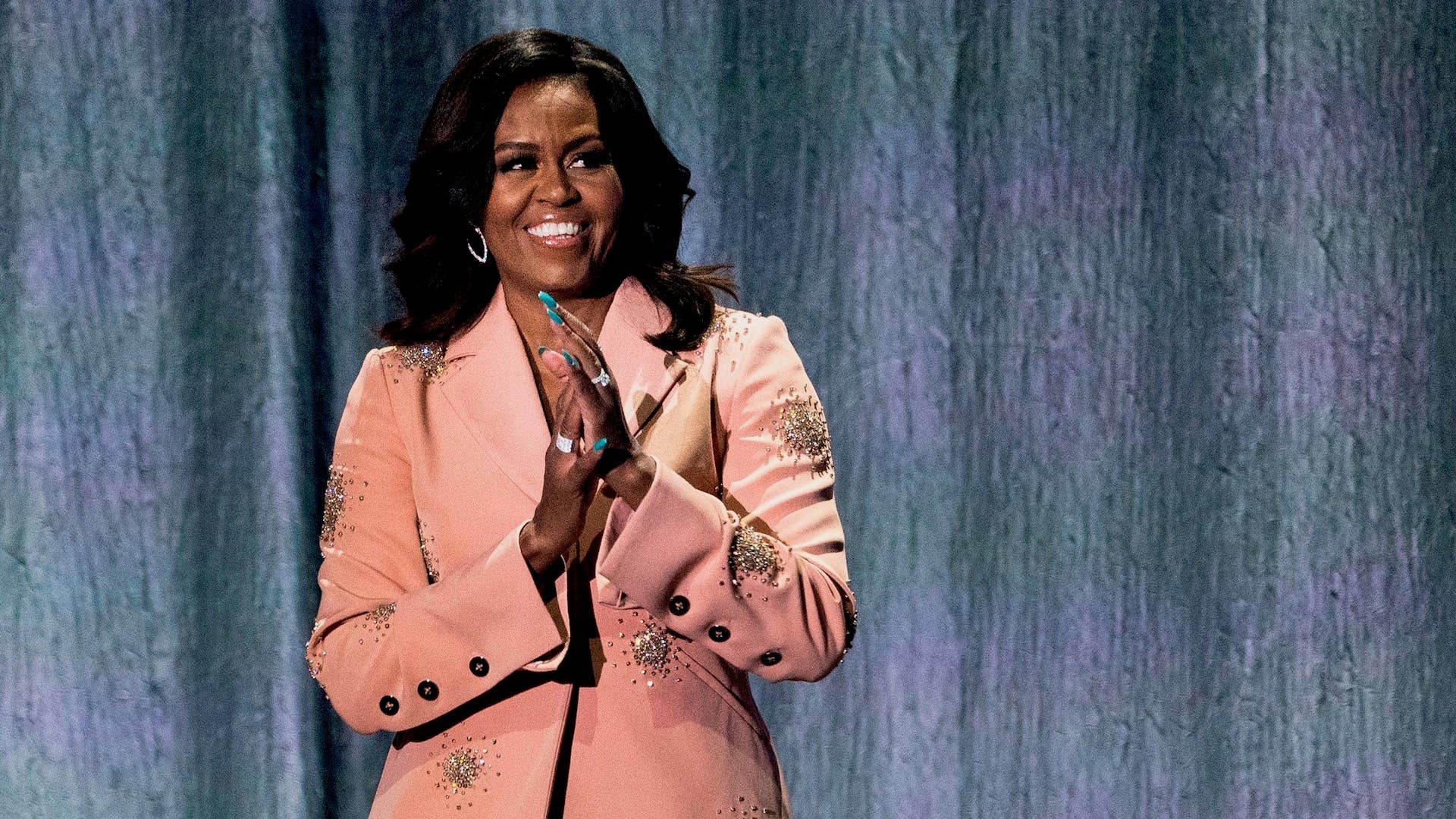 Former US first lady Michelle Obama gestures on stage of the Royal Arena