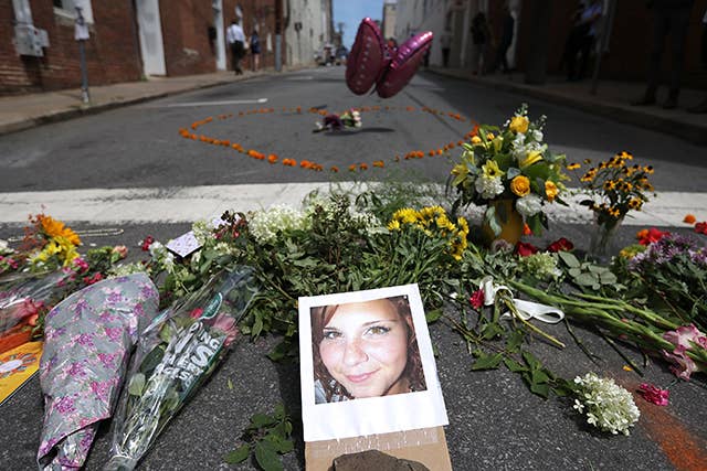 Flowers surround a photo of 32 year old Heather Heyer