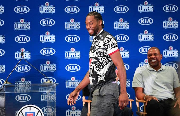 Kawhi Leonard walks past coach Doc Rivers during his Clippers introduction.