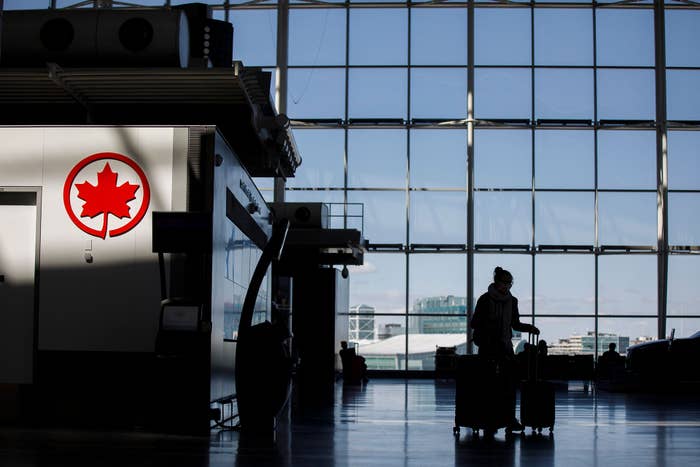 A passenger wheels her luggage near an Air Canada logo at Toronto Pearson International Airport on April 1, 2020 in Toronto, Canada.
