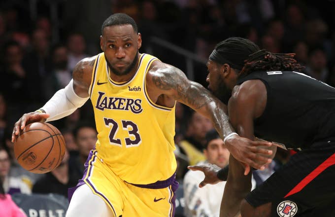 LeBron James #23 of the Los Angeles Lakers dribbles past Montrezl Harrell