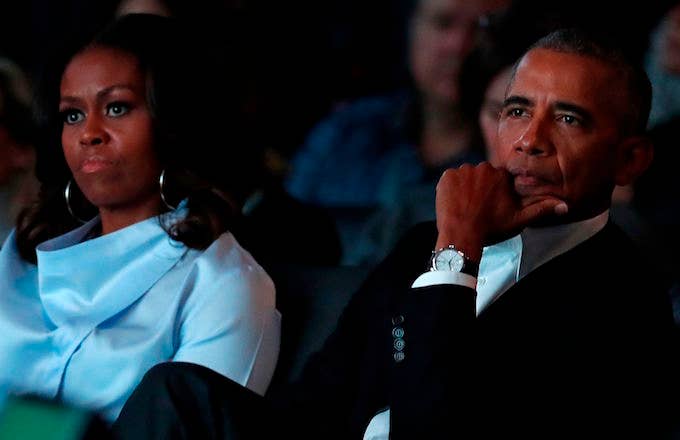 Michelle and Barack Obama listening to remarks at the Obama Foundation Summit.