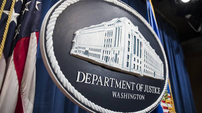 The Department of Justice logo hangs as the backdrop before a press conference