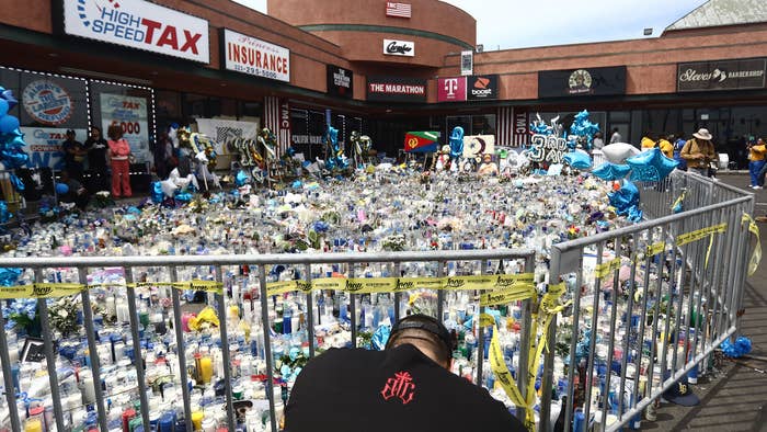 A man kneels at a memorial set up outside The Marathon Clothing store before the funeral procession for slain hip hop artist Nipsey Hussle