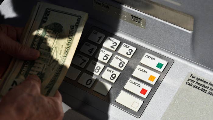 A banking customer withdraws money from a ATM machine.