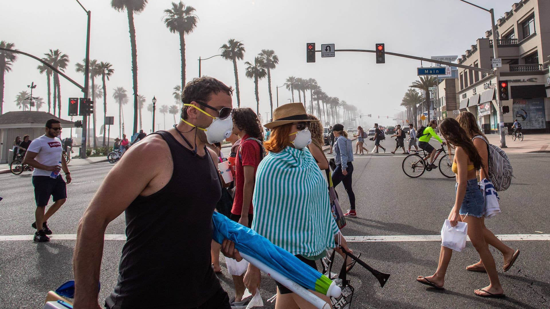 People cross the street amid coronavirus pandemic in Huntington Beach, California