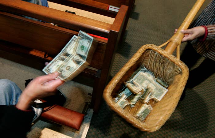 A churchgoer places money in the offering basket