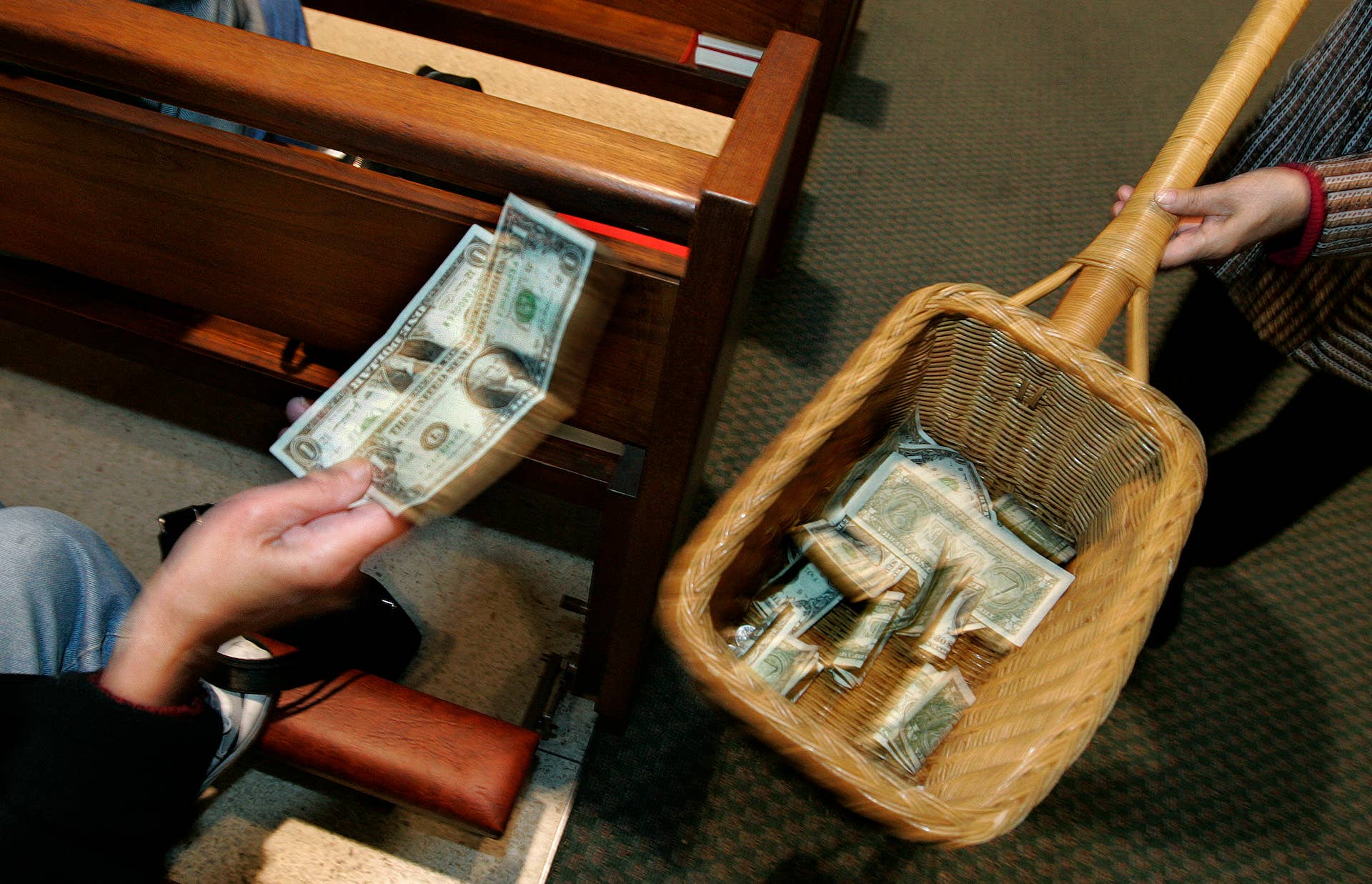 A churchgoer places money in the offering basket