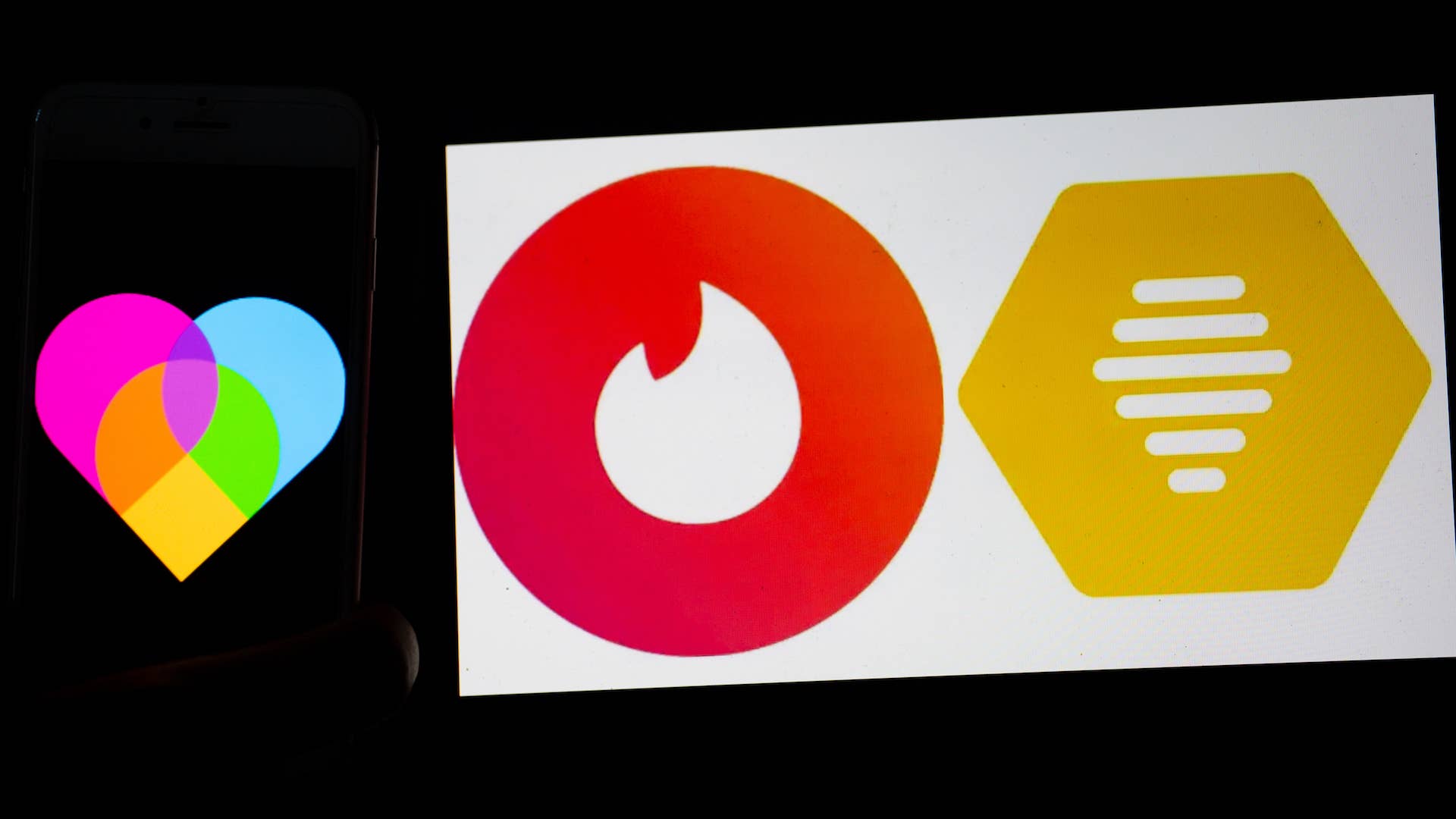 The logos of dating apps Lovoo, Tinder and bumble are seen on a mobile and laptop screen.