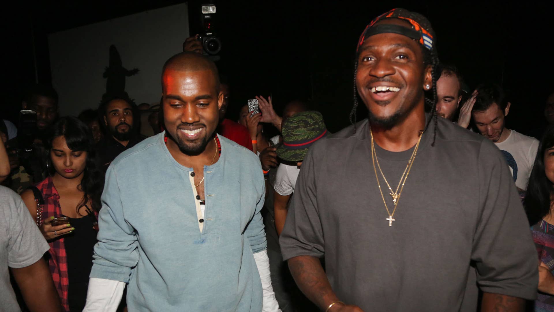 Ye and Pusha T are pictured smiling together at an event