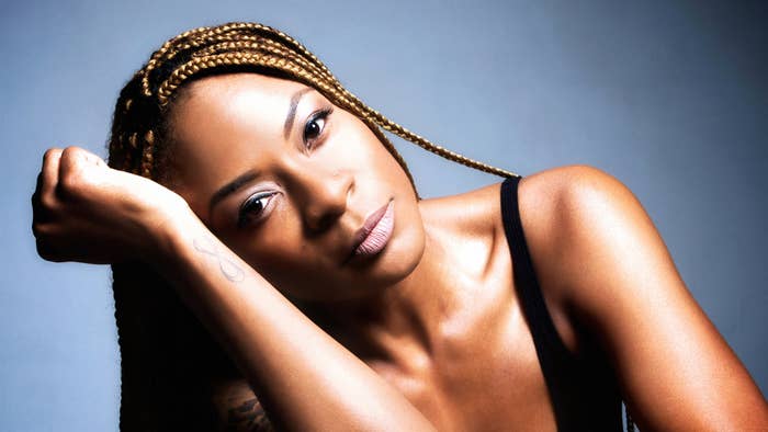 Singer Jully Black posing with her head resting on her arm