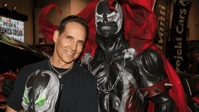 Todd McFarlane poses with a Spawn statue.