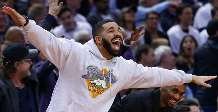 Drake with his arms spread at a game
