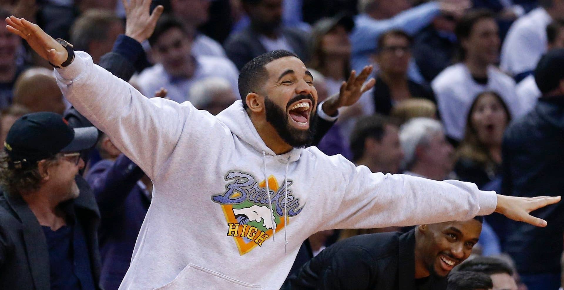 Drake with his arms spread at a game