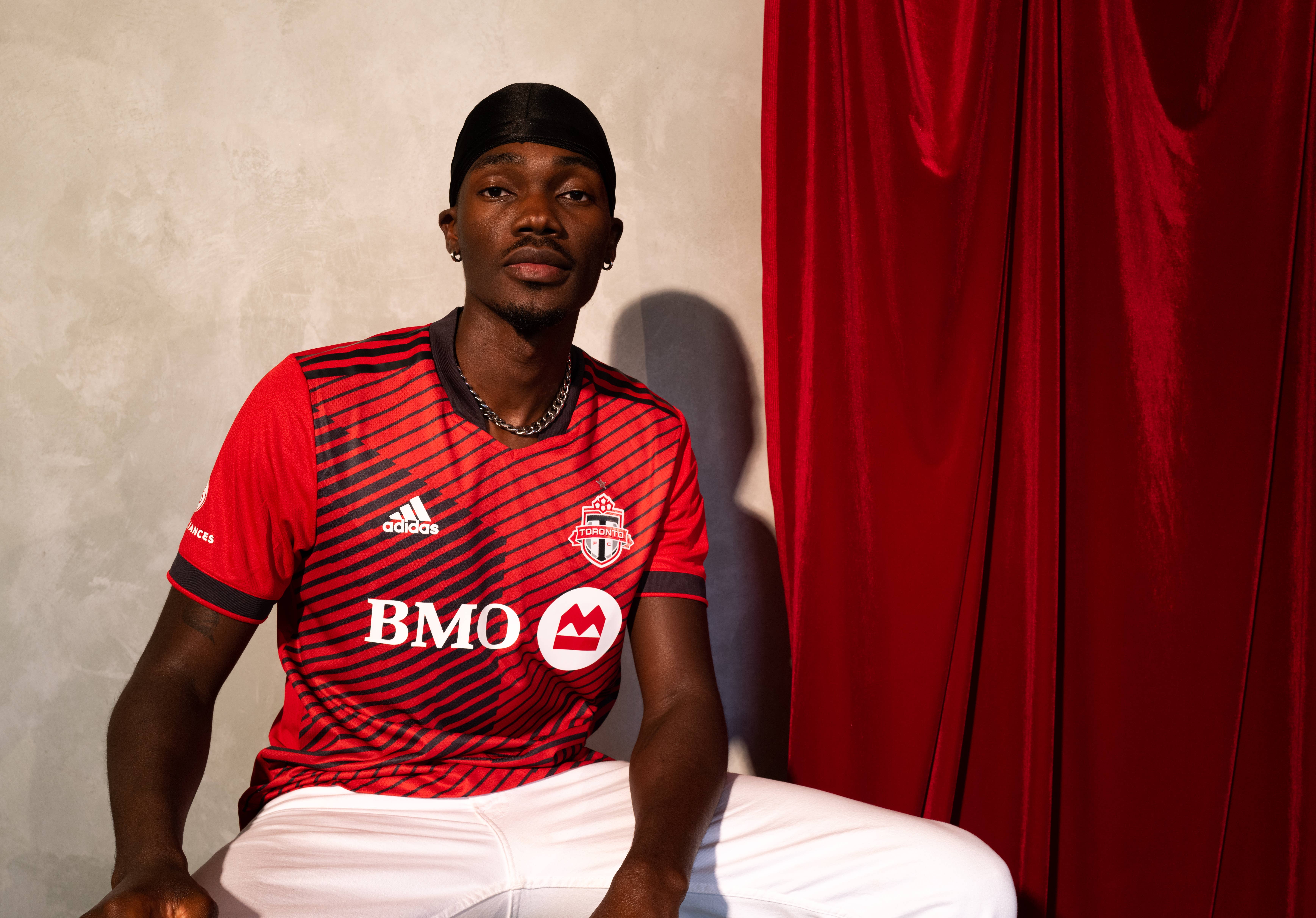 Tobi posting in a red Toronto FC jersey