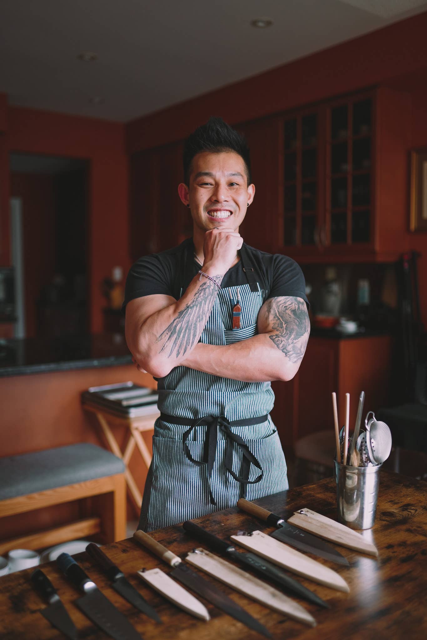Toronto chef Wallace Wong posing in front of chef knives