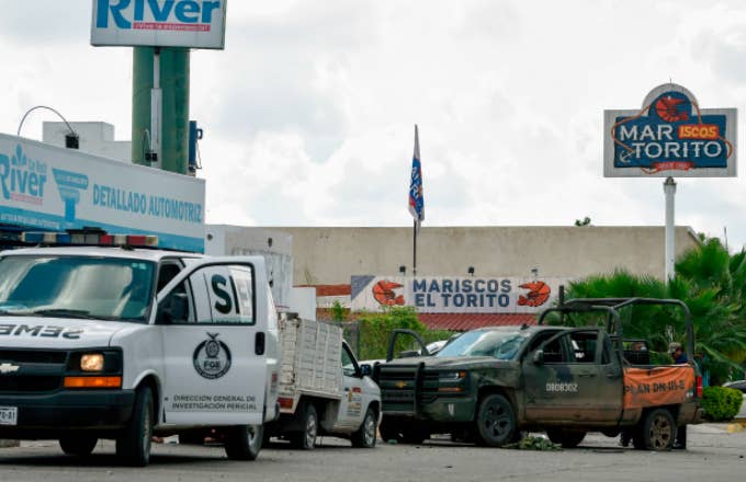 A forensic service van is seen next to a vehicle with bullet holes