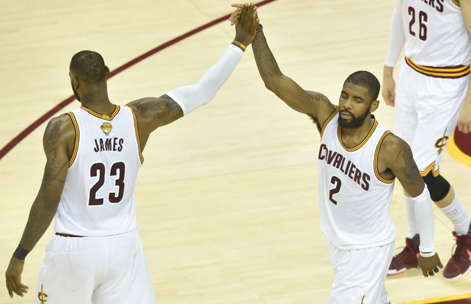 LeBron James high fives Kyrie Irving.