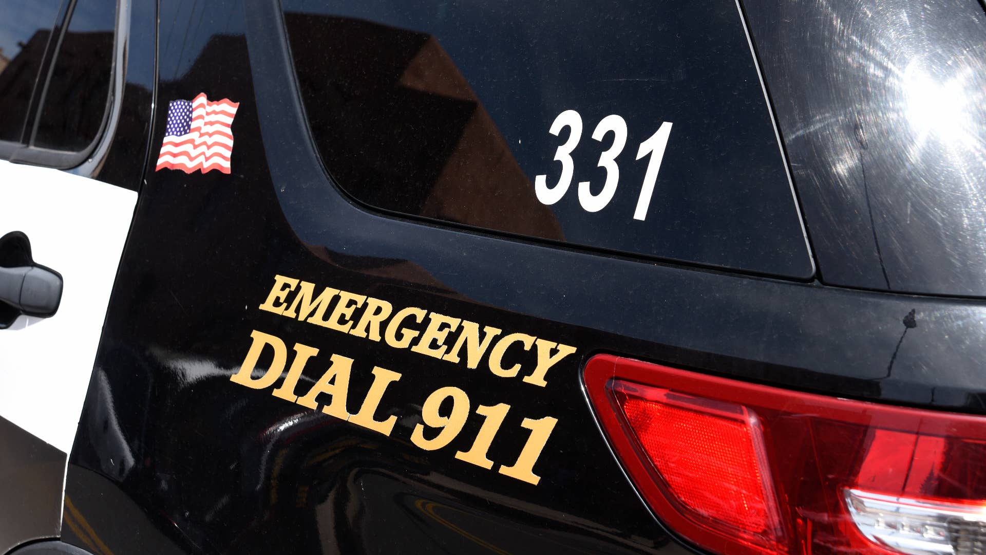 A police car with 'Emergency Dial 911' on its side parked in Santa Fe, New Mexico.