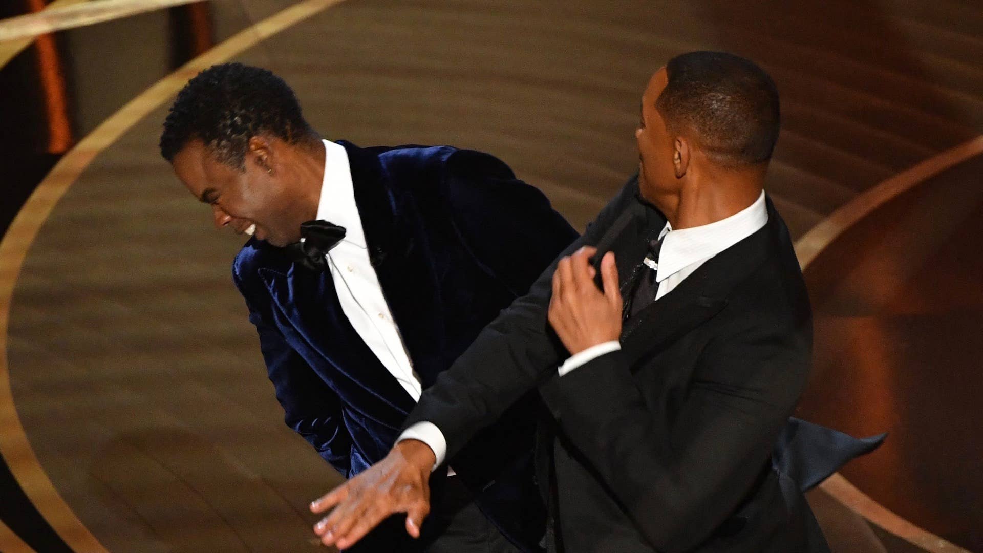 Will Smith (R) slaps US actor Chris Rock onstage during the 94th Oscars