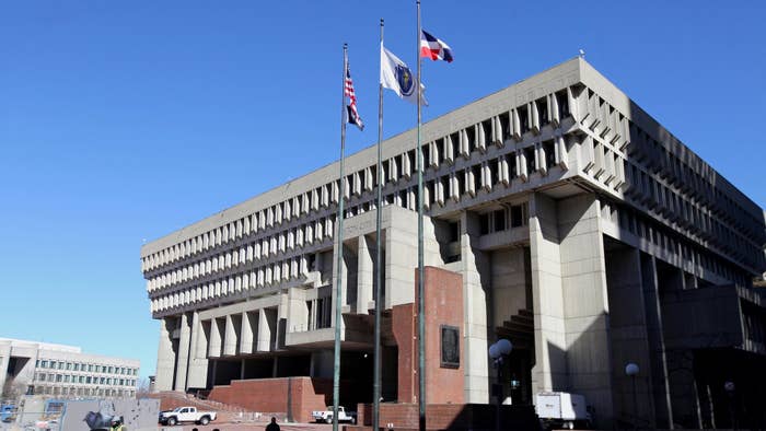 Passersby walk through Boston City Hall