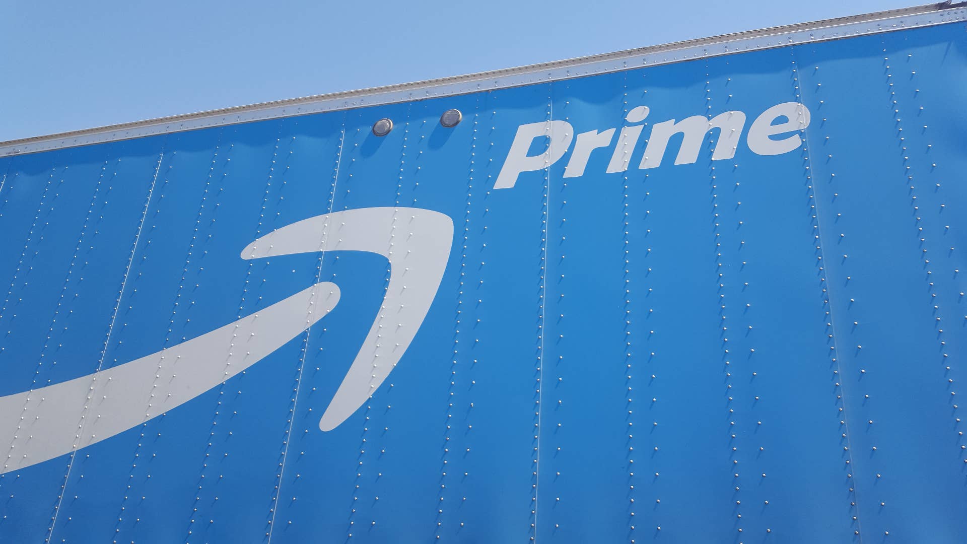The Amazon Prime logo on the side of a tractor trailer semi truck.