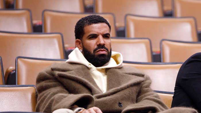 Drake sits with Toronto Raptors president Masai Ujiri