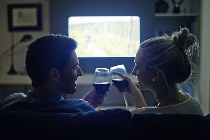 A couple drinking wine and watching TV