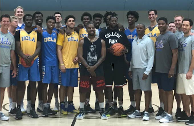 Kanye West and 2 Chainz pose for a photo with the UCLA Bruins basketball team.
