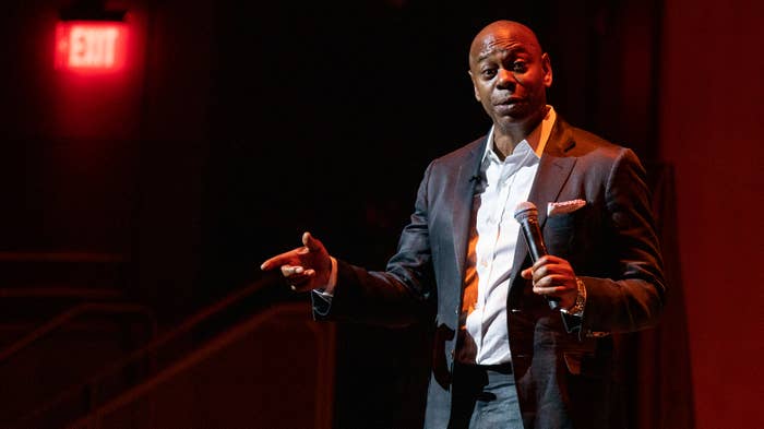 Dave Chappelle seen speaking to audience onstage.