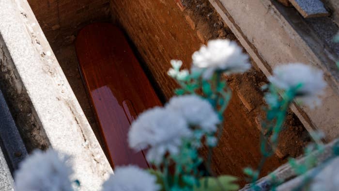 Casket pictured being lowered during burial.