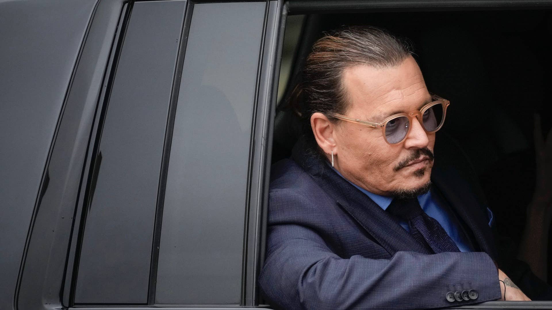 Actor Johnny Depp sits in his vehicle as he departs the Fairfax County Courthouse