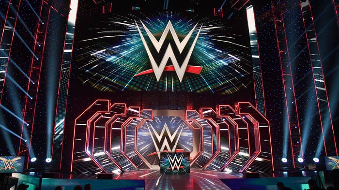 WWE logos are shown on screens before a WWE news conference at T-Mobile Arena.
