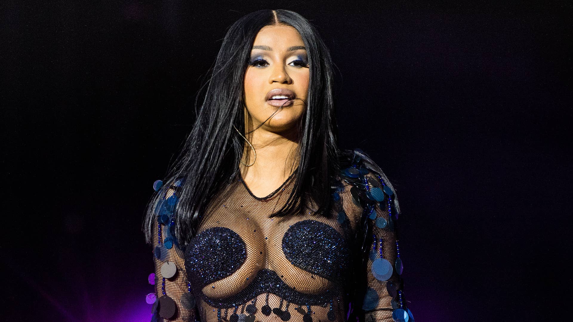 Cardi B photographed while performing onstage at a festival.