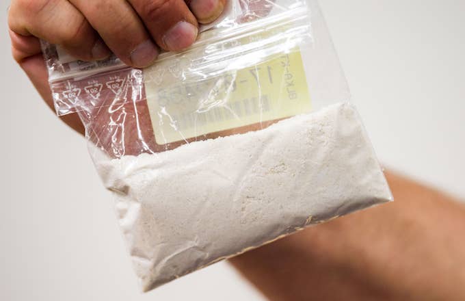 Curator of the Store Room of the Public Prosecution Service holding bag with confiscated cocaine.