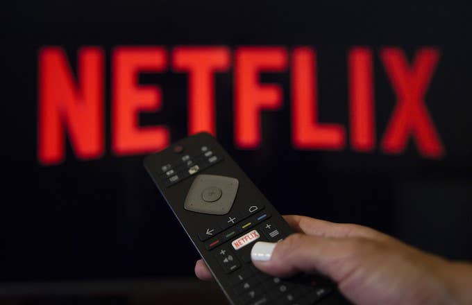 A person holds a Netflix remote control.