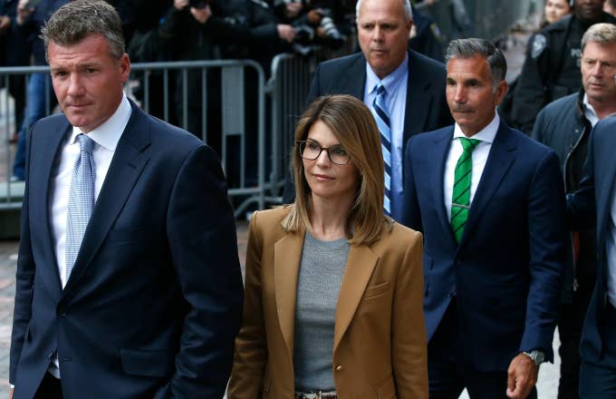 Lori Loughlin leaves as her husband Mossimo Giannulli, in green tie at right, follows