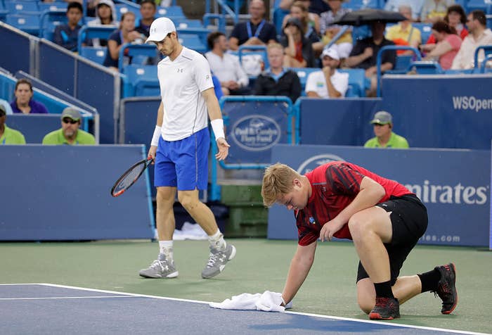 ball boy dries tennis court