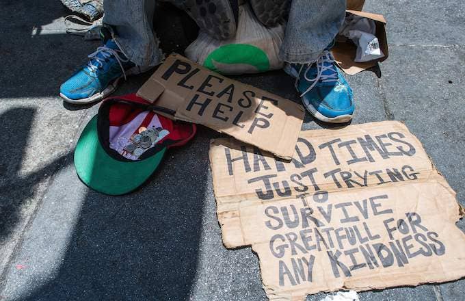 Homeless person begs along a sidewalk in downtown San Francisco