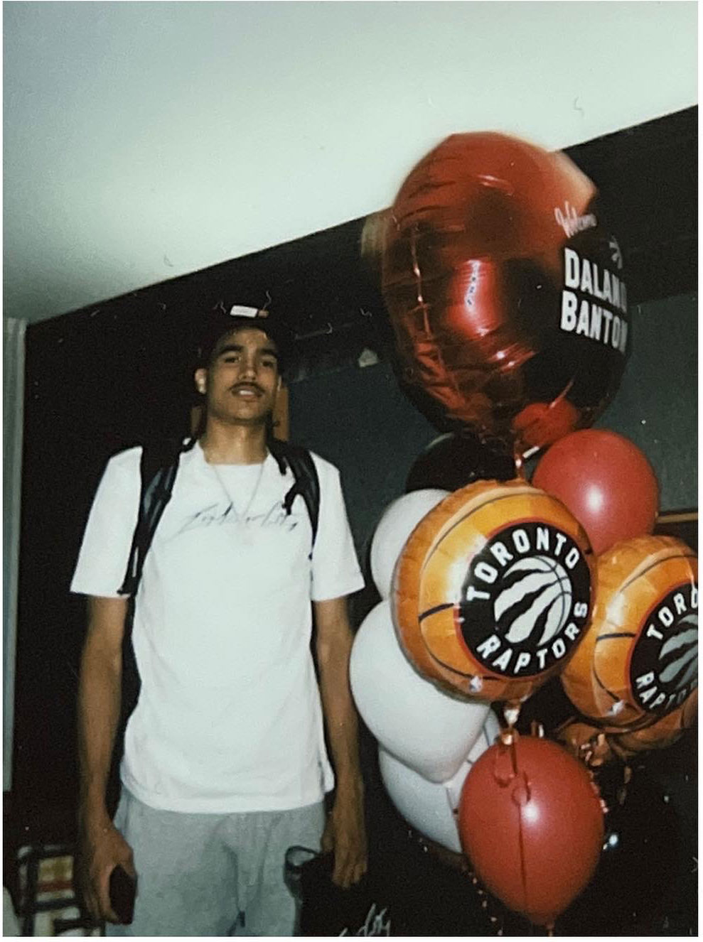 Raptors rookie Dalano Banton stands with &quot;Welcome&quot; balloons