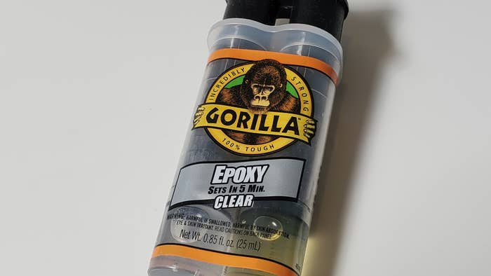 Close-up shot of a Gorilla Glue epoxy glue bottle with the company logo prominent.