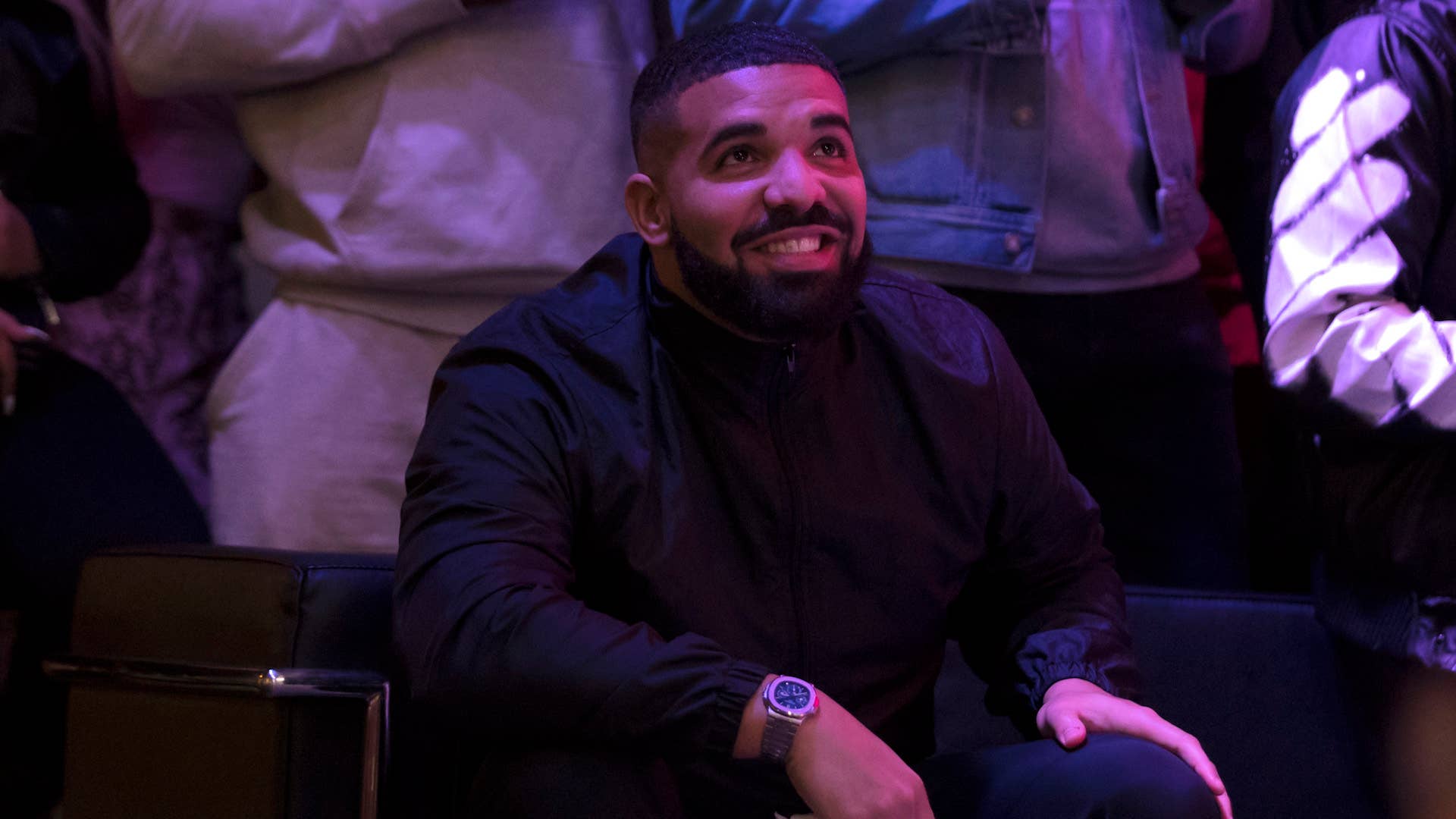 Drake watches a screen alongside other Toronto Raptors fans.