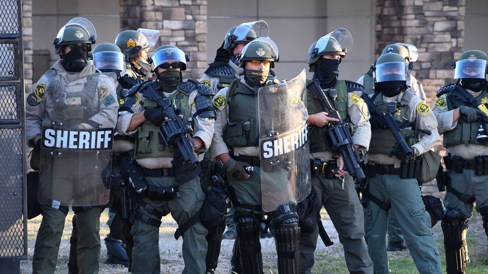 Sheriff's in riot gear stand in front of the South L.A. Sheriff's Station