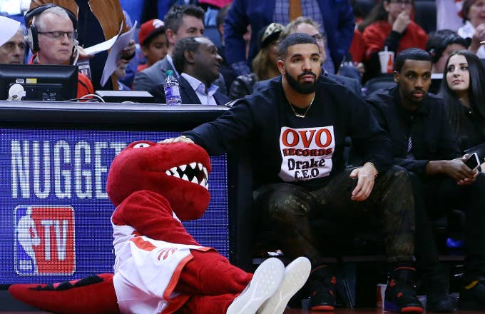 Toronto Raptors mascot, The Raptor, gets a pat on the head from singer Drake