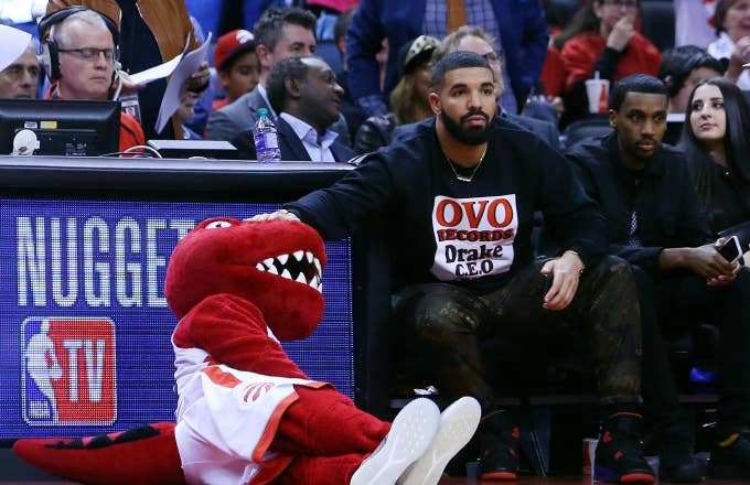Toronto Raptors mascot, The Raptor, gets a pat on the head from singer Drake