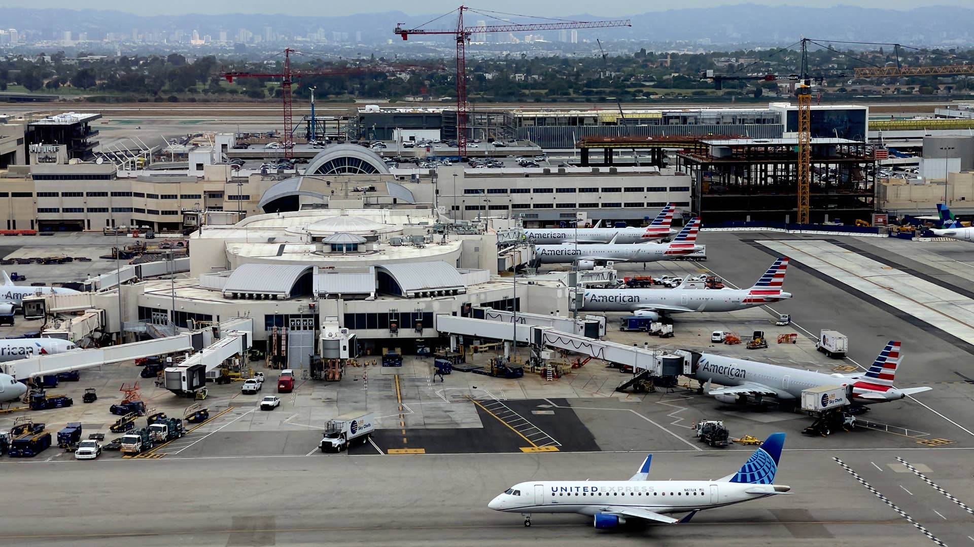 A United Express plane drives by the American Air Lines hub at Los Angeles International Airport