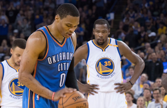Kevin Durant looks on as Russell Westbrook shoots a free throw.